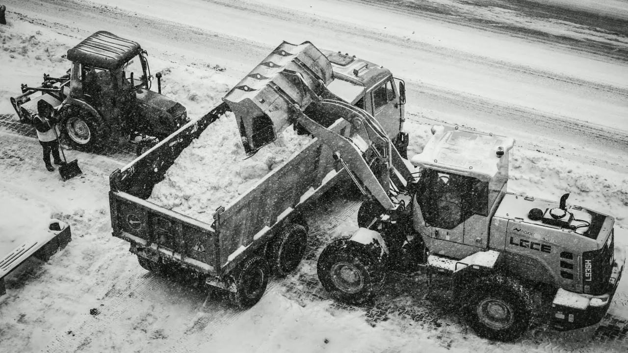 Loader filling a dump truck with snow