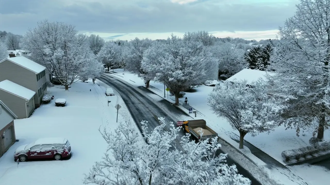 Aerial view of a salt truck treating a snowy road